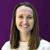 Dr Molly Dineen smiles in front of a purple background. 